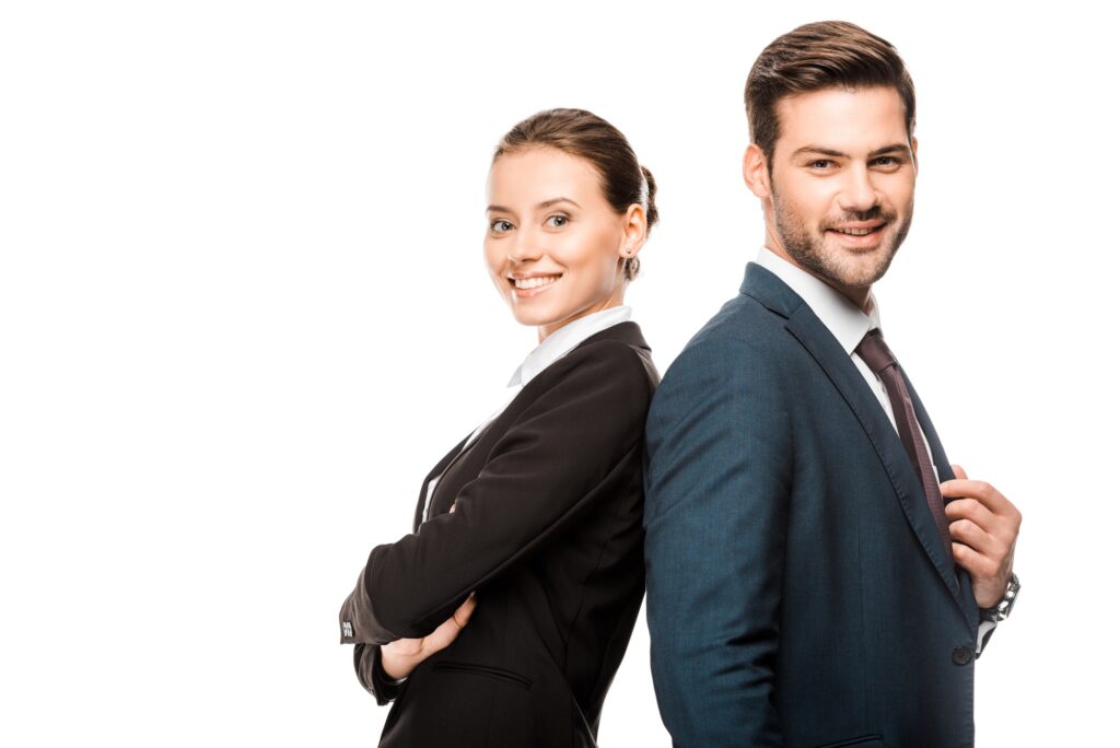 happy young business partners leaning back to back and looking at camera isolated on white